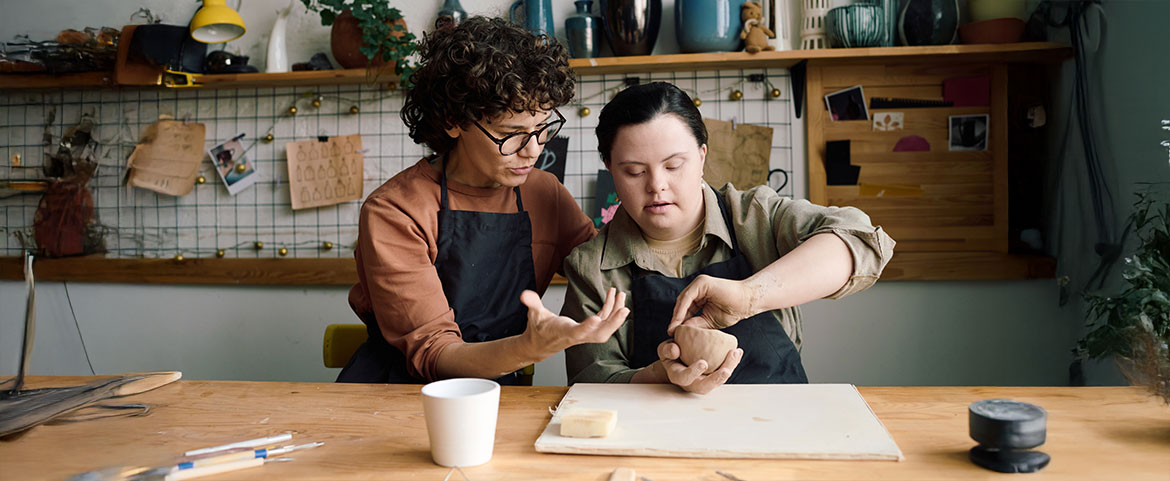 A young adult with Down syndrome making pottery