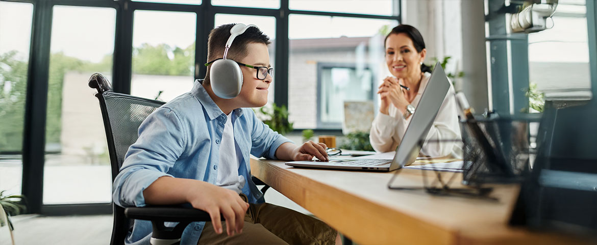 Info & Enrollment, a young adult with Down syndrome and a headset on looking at a monitor